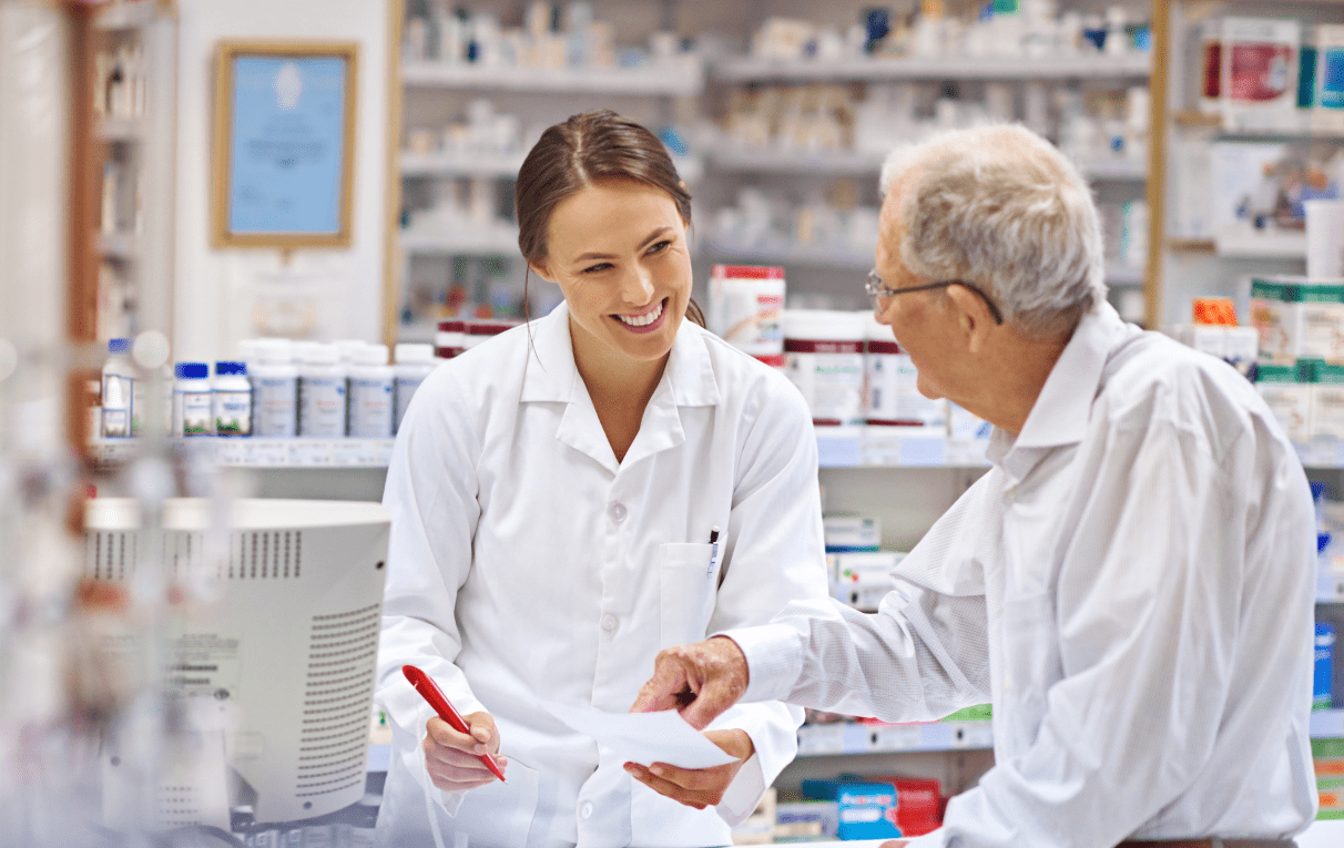 Pharmacist in a white lab coat consulting with an elderly man